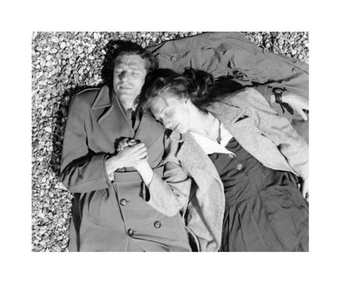 A couple lying together on Brighton Beach c. 1955