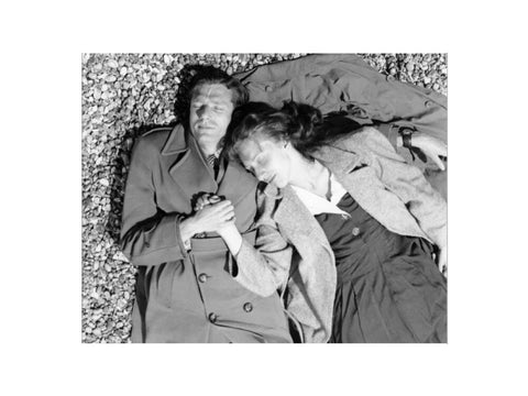 A couple lying together on Brighton Beach c. 1955