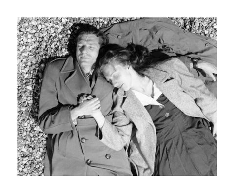 A couple lying together on Brighton Beach c. 1955