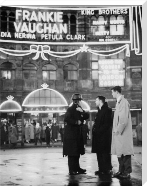 A group of men talking outside the Palace Theatre Shaftsbury Avenue c. 1955