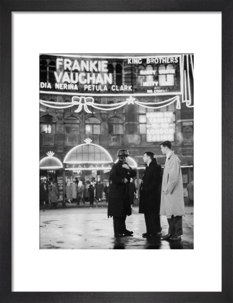 A group of men talking outside the Palace Theatre Shaftsbury Avenue c. 1955