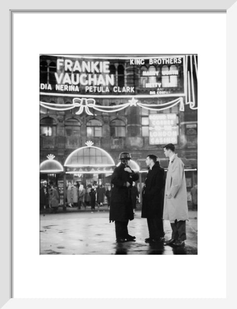 A group of men talking outside the Palace Theatre Shaftsbury Avenue c. 1955