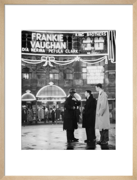 A group of men talking outside the Palace Theatre Shaftsbury Avenue c. 1955