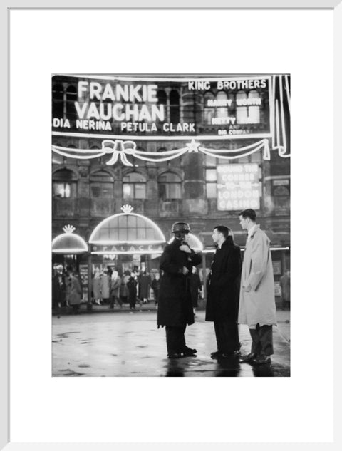 A group of men talking outside the Palace Theatre Shaftsbury Avenue c. 1955