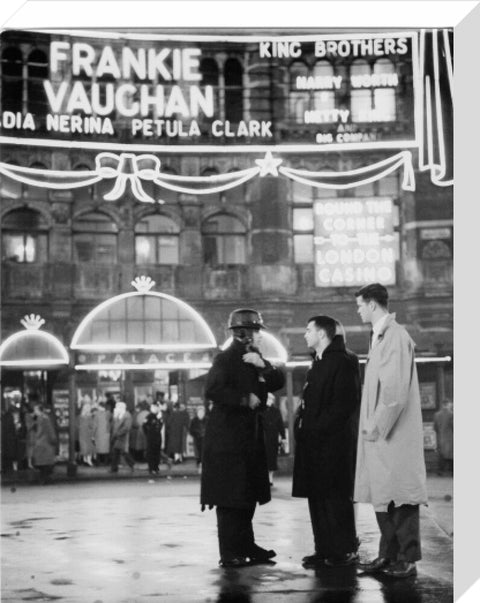 A group of men talking outside the Palace Theatre Shaftsbury Avenue c. 1955