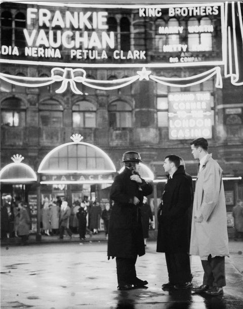 A group of men talking outside the Palace Theatre Shaftsbury Avenue c. 1955