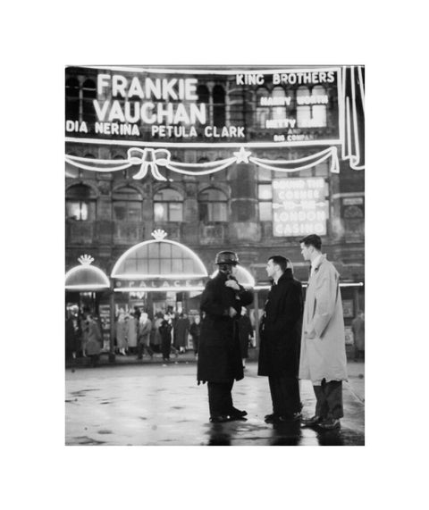 A group of men talking outside the Palace Theatre Shaftsbury Avenue c. 1955