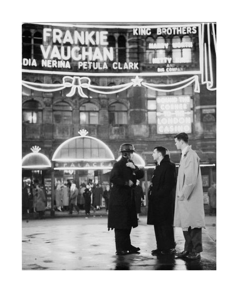 A group of men talking outside the Palace Theatre Shaftsbury Avenue c. 1955