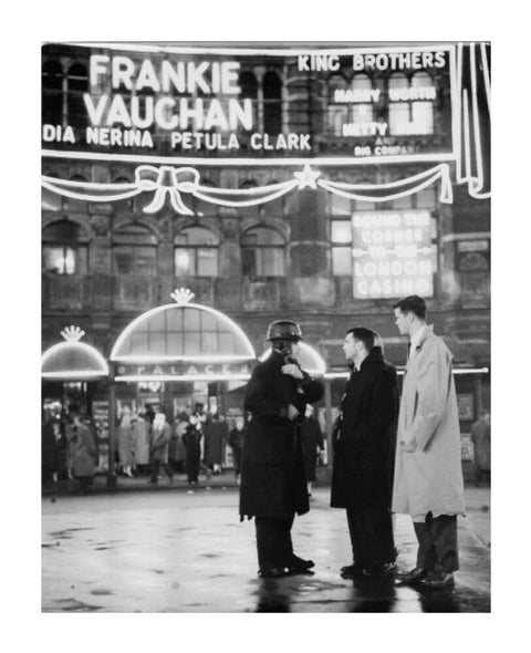 A group of men talking outside the Palace Theatre Shaftsbury Avenue c. 1955