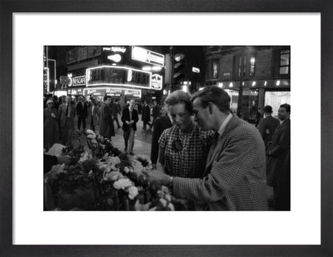 Man buying a woman a flower in the West End 1960