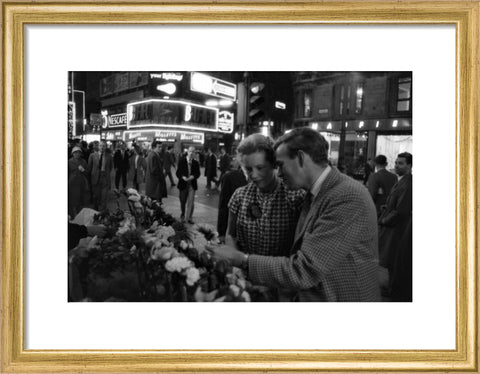 Man buying a woman a flower in the West End 1960