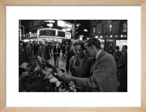 Man buying a woman a flower in the West End 1960