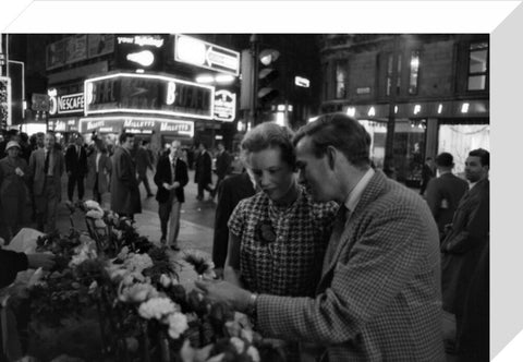 Man buying a woman a flower in the West End 1960