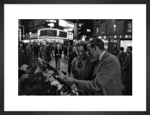 Man buying a woman a flower in the West End 1960