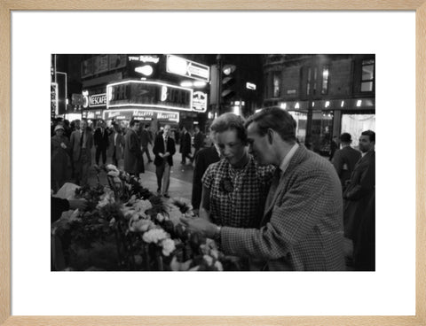 Man buying a woman a flower in the West End 1960