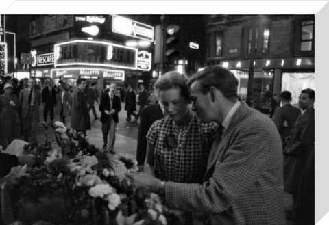 Man buying a woman a flower in the West End 1960