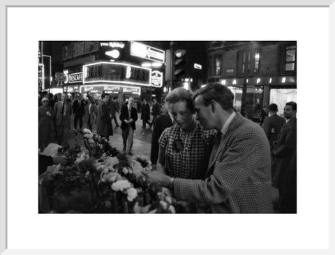 Man buying a woman a flower in the West End 1960