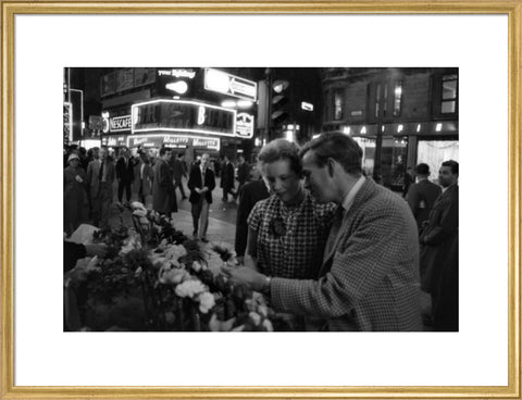 Man buying a woman a flower in the West End 1960