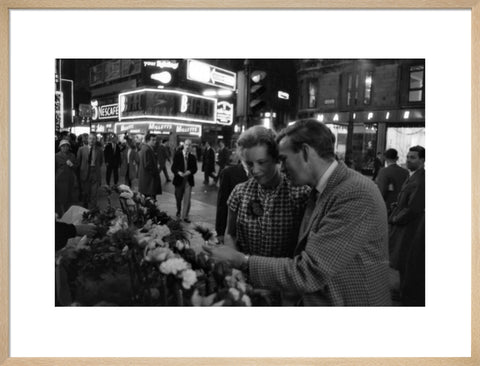 Man buying a woman a flower in the West End 1960