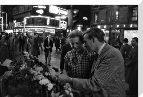 Man buying a woman a flower in the West End 1960