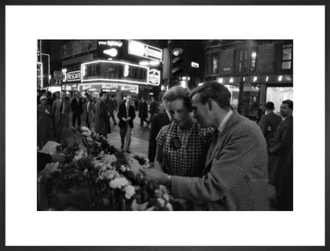 Man buying a woman a flower in the West End 1960