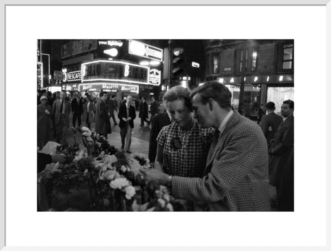 Man buying a woman a flower in the West End 1960