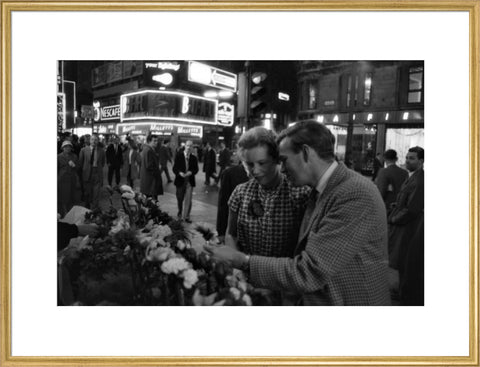 Man buying a woman a flower in the West End 1960