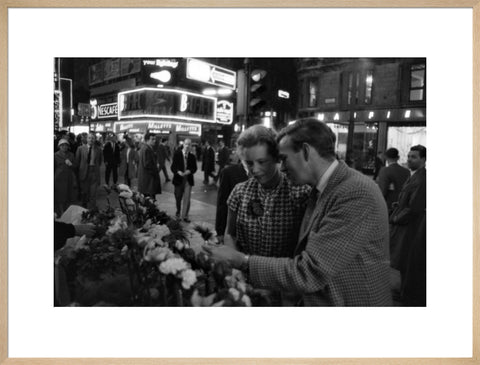 Man buying a woman a flower in the West End 1960