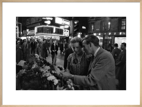 Man buying a woman a flower in the West End 1960