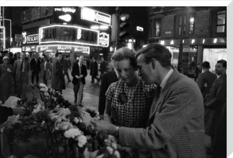 Man buying a woman a flower in the West End 1960