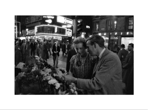 Man buying a woman a flower in the West End 1960