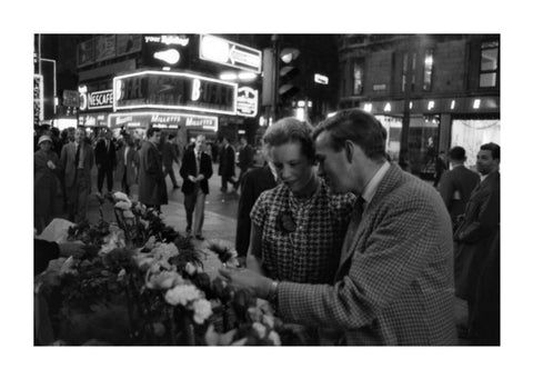 Man buying a woman a flower in the West End 1960