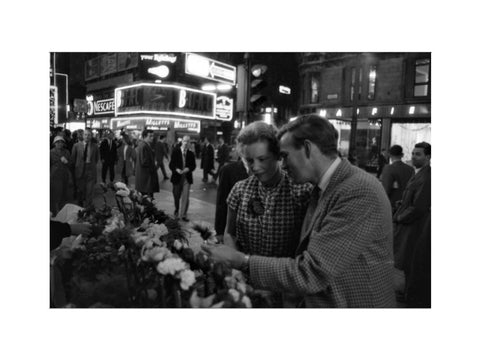 Man buying a woman a flower in the West End 1960