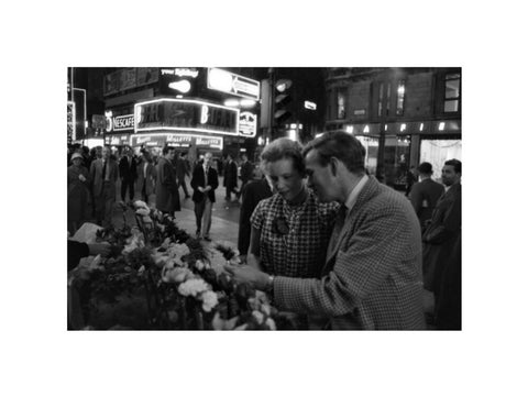 Man buying a woman a flower in the West End 1960