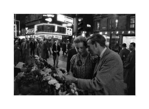 Man buying a woman a flower in the West End 1960