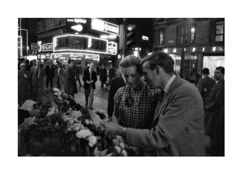 Man buying a woman a flower in the West End 1960