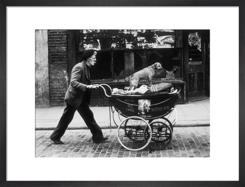 Man pushing a pram containing his wares and a standing dog 1961