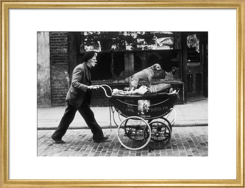 Man pushing a pram containing his wares and a standing dog 1961