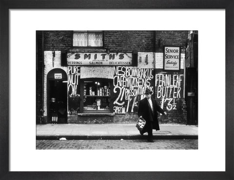 Man in an overcoat and hat crosses the road 1961