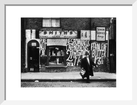 Man in an overcoat and hat crosses the road 1961