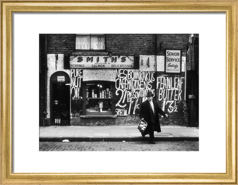 Man in an overcoat and hat crosses the road 1961