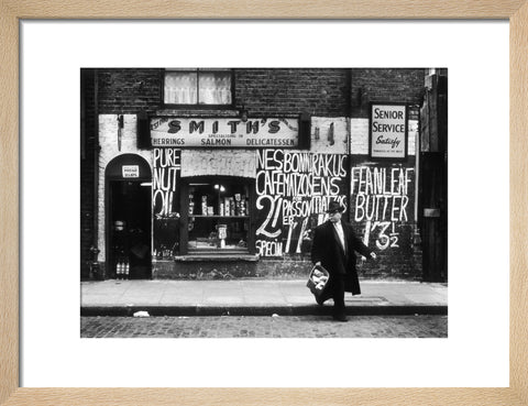 Man in an overcoat and hat crosses the road 1961