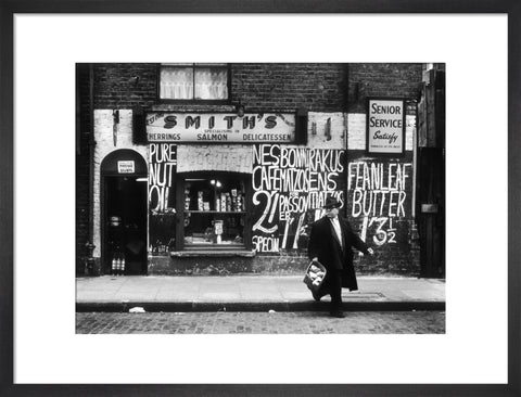 Man in an overcoat and hat crosses the road 1961