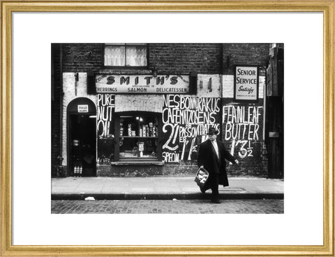 Man in an overcoat and hat crosses the road 1961