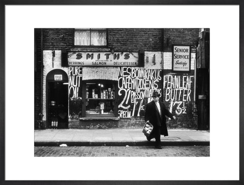 Man in an overcoat and hat crosses the road 1961
