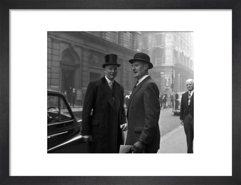 Three formally dressed men on a street flanked by high buildings. c.1955