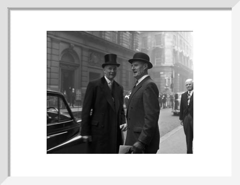 Three formally dressed men on a street flanked by high buildings. c.1955