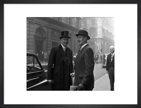 Three formally dressed men on a street flanked by high buildings. c.1955