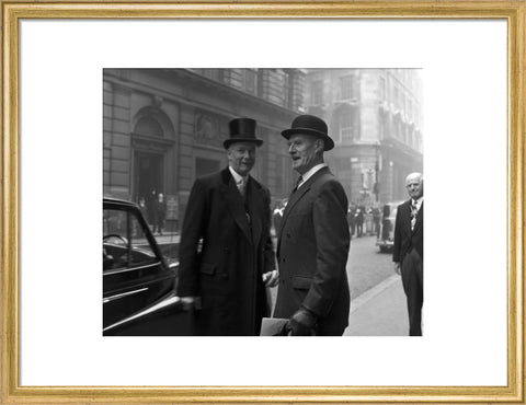 Three formally dressed men on a street flanked by high buildings. c.1955