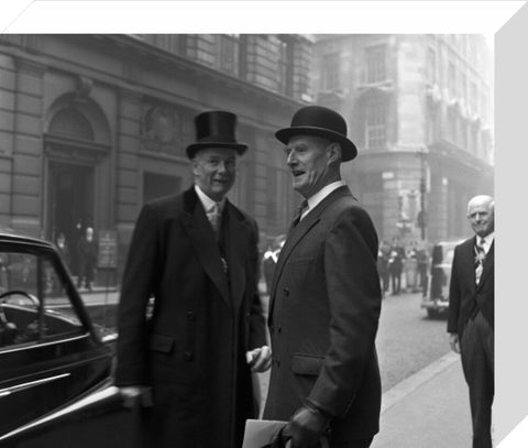 Three formally dressed men on a street flanked by high buildings. c.1955